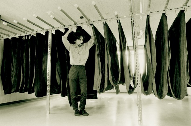 Yohji Yamamoto among fabric rails, Tokyo, 1981<br />
