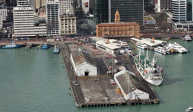 This image of two warehouses on the waterfront captures the stages of construction of Queen's Wharf